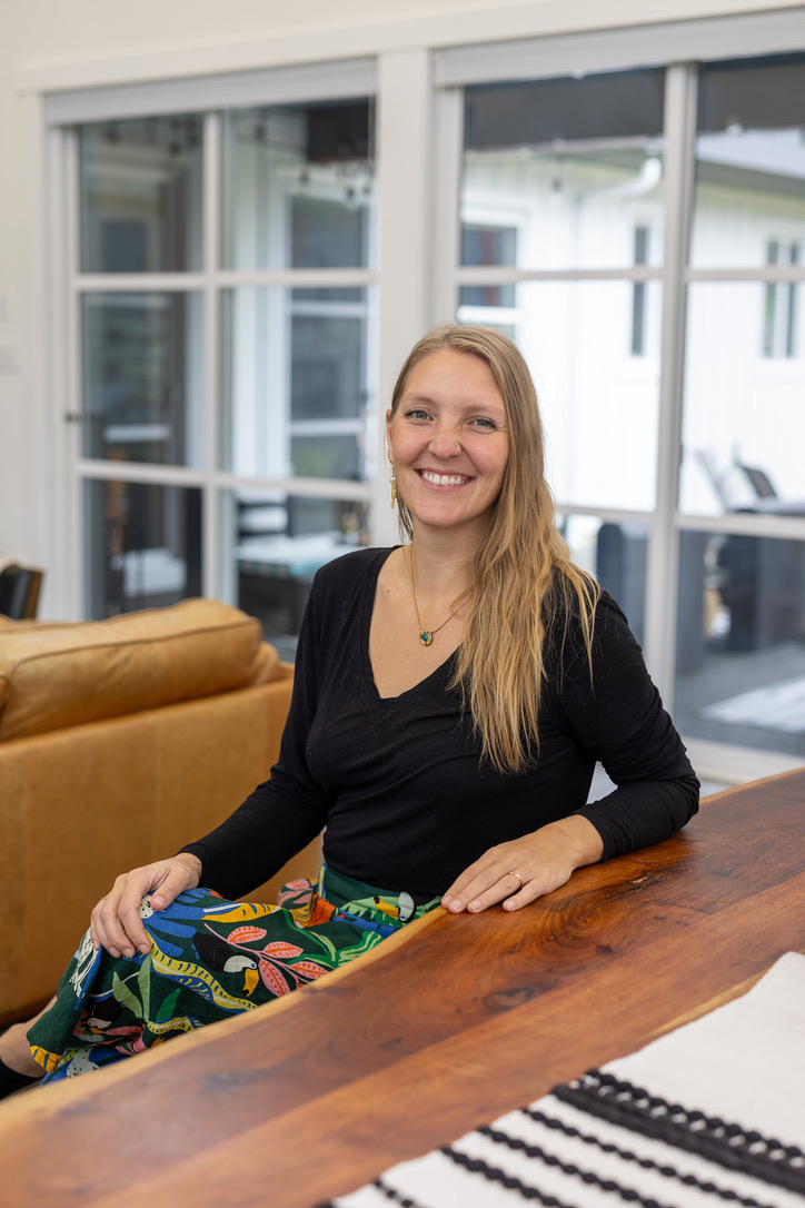 Samantha, the person behind sunshine¢s, smiling at a wooden table